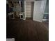 Kitchen area featuring wood flooring, white cabinets, and adjacent shelving at 5028 Highway 81, Mcdonough, GA 30252
