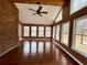 Bright sunroom with brick accent wall, hardwood floors, many windows, and ceiling fan at 325 Northmill Pkwy, Stockbridge, GA 30281