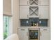 Elegant bar area featuring custom cabinets, wine storage, beverage fridge, and herringbone backsplash at 750 Tannery Cmn, Alpharetta, GA 30009