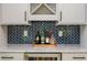 Stylish bar area with decorative backsplash, wine storage, and elegant countertops at 750 Tannery Cmn, Alpharetta, GA 30009