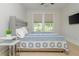 This bedroom features a stylish patterned quilt, complementing the natural light streaming through the window at 750 Tannery Cmn, Alpharetta, GA 30009