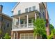 Charming two-story home with a brick foundation, inviting front porch, and a lush green tree at 750 Tannery Cmn, Alpharetta, GA 30009
