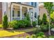 Attractive landscaping leading to a cozy covered porch with hanging pendant lights at 750 Tannery Cmn, Alpharetta, GA 30009