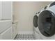 Laundry room featuring front load washer and dryer, stylish floor tiles, and plenty of storage at 750 Tannery Cmn, Alpharetta, GA 30009
