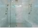 A luxurious glass-enclosed shower features dual shower heads, a bench, and marble surround at 750 Tannery Cmn, Alpharetta, GA 30009