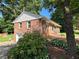 Rear exterior view of home, showing lush landscaping, brick and attached garage at 2059 Clearwater Se Dr, Marietta, GA 30067