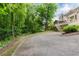 Large backyard with driveway leading to a home with a screened-in porch and lush greenery at 2552 Berwick Walk, Snellville, GA 30078