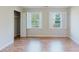 Bright bedroom featuring wood floors, white walls, closet, and windows with natural light at 2552 Berwick Walk, Snellville, GA 30078