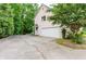 A view of a home's side and garage, along with a driveway and trees surrounding the property at 2552 Berwick Walk, Snellville, GA 30078