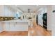 Updated kitchen overlooks spacious hardwood floors with bright white cabinetry and counters, with stainless appliances at 2552 Berwick Walk, Snellville, GA 30078