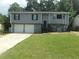 Charming gray two-story home featuring a well-manicured lawn and a two-car garage at 2845 Woodhollow Ln, Jonesboro, GA 30236