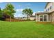 Large, green backyard with a wooden fence, offering ample space for outdoor activities and privacy at 3700 Terrasol Sw Trl, Lilburn, GA 30047