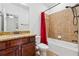 Bathroom features a shower-tub combination with brown tile and a cherry vanity with granite counter at 3700 Terrasol Sw Trl, Lilburn, GA 30047