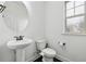 Clean half bath with white fixtures, pedestal sink, and a window for natural light at 3700 Terrasol Sw Trl, Lilburn, GA 30047