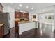 Well-lit kitchen featuring a large island with granite countertops, stainless steel appliances, and dark hardwood floors at 3700 Terrasol Sw Trl, Lilburn, GA 30047