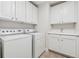Clean and bright laundry room featuring white cabinetry, sink, and modern washer and dryer appliances at 3700 Terrasol Sw Trl, Lilburn, GA 30047