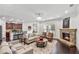 Open-concept living room with a stone fireplace, hardwood floors, modern lighting, and seamless flow to kitchen at 3700 Terrasol Sw Trl, Lilburn, GA 30047