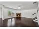 Spacious living room with hardwood floors, a stone fireplace, a modern chandelier, and large bright windows at 3700 Terrasol Sw Trl, Lilburn, GA 30047