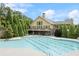 Large community pool with plenty of lounge chairs and a clubhouse with an upper balcony and stone accents at 3700 Terrasol Sw Trl, Lilburn, GA 30047