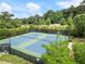 Overhead view of the fenced in community tennis courts surrounded by lush green landscaping at 3700 Terrasol Sw Trl, Lilburn, GA 30047