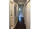 Clean hallway leading to a bathroom with white cabinets and an open door to a room with hardwood floors at 4324 Rocklane Dr, Conley, GA 30288