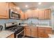A well-lit kitchen with stainless steel appliances, granite countertops, and wooden cabinets at 4324 Rocklane Dr, Conley, GA 30288