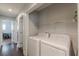 Convenient laundry area with modern white washer and dryer, plus storage shelves at 4324 Rocklane Dr, Conley, GA 30288