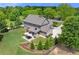An open backyard featuring mature trees, a stone patio with dining set, and a well-manicured lawn at 592 Hayes Rd, Auburn, GA 30011