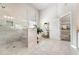 Bright bathroom features walk-in shower, large soaking tub, neutral tile, and natural light from window at 592 Hayes Rd, Auburn, GA 30011