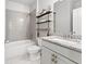 Modern bathroom featuring a granite countertop vanity, a tiled shower-tub, and decorative shelving at 592 Hayes Rd, Auburn, GA 30011