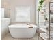 Elegant bathroom features neutral paint and tile, large soaking tub and chrome towel rack at 592 Hayes Rd, Auburn, GA 30011