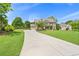 Sprawling lawn leads to an attractive brick home with attached garage and lush landscaping at 592 Hayes Rd, Auburn, GA 30011