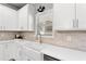 Charming kitchen featuring a farmhouse sink, white cabinets, light countertops, and modern fixtures at 592 Hayes Rd, Auburn, GA 30011