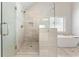 Modern bathroom features walk-in shower with neutral tile, rainfall showerhead, and built-in bench at 592 Hayes Rd, Auburn, GA 30011