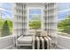 Window seat with patterned curtains offering natural light and pleasant outdoor views at 592 Hayes Rd, Auburn, GA 30011