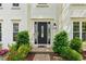 Elegant front entrance featuring a stylish black door, decorative sidelights, and vibrant landscaping at 1667 Willow Way, Woodstock, GA 30188
