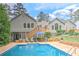 Large backyard featuring a swimming pool, patio area, and a home with an elevated deck and lush green landscaping at 4546 Windsor Oaks Ct, Marietta, GA 30066