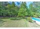 Large, private backyard with mature trees, lawn and pool, perfect for outdoor gatherings or a relaxing getaway at 4546 Windsor Oaks Ct, Marietta, GA 30066