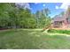 Expansive backyard with manicured lawn, mature trees, and a deck, perfect for enjoying the outdoors at 4546 Windsor Oaks Ct, Marietta, GA 30066