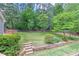 Large backyard with stone steps, lush green grass, and a retaining wall at 4546 Windsor Oaks Ct, Marietta, GA 30066