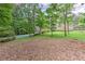 Expansive backyard with mature trees, grass and partial view of the home's pool at 4546 Windsor Oaks Ct, Marietta, GA 30066