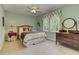 Bright bedroom featuring a window with natural light, light green walls and neutral carpet at 4546 Windsor Oaks Ct, Marietta, GA 30066