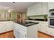 Kitchen with hardwood floors, white cabinetry, stainless appliances, and center island cooktop at 4546 Windsor Oaks Ct, Marietta, GA 30066
