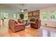 Comfortable living room featuring hardwood floors, brick fireplace, and ample natural light at 4546 Windsor Oaks Ct, Marietta, GA 30066