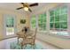 Sunroom featuring a glass table set, flooded with natural light and views of the lush backyard and pool at 4546 Windsor Oaks Ct, Marietta, GA 30066