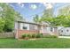 Charming single-story home featuring a brick facade, gray siding, landscaped front yard, and covered entryway at 947 Rebel Forest Dr, Atlanta, GA 30315