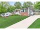 A charming single-story home with a long driveway, brick facade, gray siding, and well-manicured lawn at 947 Rebel Forest Dr, Atlanta, GA 30315