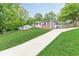 Charming single-story home with a long driveway, brick facade, gray siding, and well-manicured lawn at 947 Rebel Forest Dr, Atlanta, GA 30315