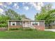 Charming single-story home featuring a brick facade, gray siding, landscaped front yard, and covered entryway at 947 Rebel Forest Dr, Atlanta, GA 30315