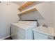 Bright laundry room with utility sink, shelving, and a washer/dryer at 947 Rebel Forest Dr, Atlanta, GA 30315